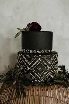 a black and white wedding cake sitting on top of a wicker basket