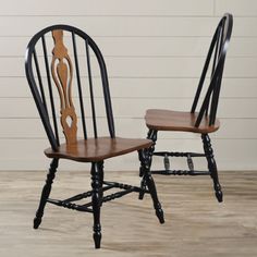 two black and brown chairs sitting side by side on top of a hard wood floor