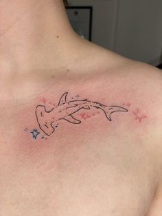 a woman's chest with a dolphin tattoo on it