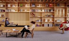 two people are sitting in chairs and reading books