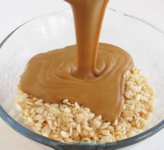 peanut butter being poured into oatmeal in a glass bowl