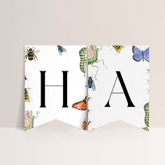 two folded cards with the letter h and butterflies on them, both have black letters