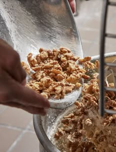 a person scooping some food out of a metal bowl