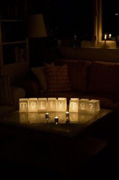 candles are lit in the shape of letters on a coffee table