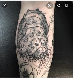 a tattoo on the leg of a person with an animal and flowers around it's legs