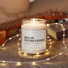 a candle sitting on top of a table next to a string of lights and a guitar