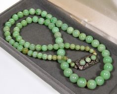 "All original jadeite jade bead necklace from 1920's. Fine polished graduated undyed natural jadeite jade beads are of a great green color. The largest beads are 10 mm (3/8\"), the smallest are 5 mm (3/16\"). The necklace is 22 1/2\" long ending with sterling silver push-in clasp adorned with 3 jade cabochons of the same color as the other beads. The clasp is also embellished with beautiful grape leaves repousse. It measures just under 1\" long, 3/8\" wide. There is no hallmarks, the clasp teste Cheap Jade Beaded Jewelry, Luxury Jade Jewelry With 108 Beads, Luxury Jade Jewelry With Gemstone Beads, Cheap Beaded Jade Jewelry, Cheap Jade Gemstone Bead Necklaces, Affordable Jade Gemstone Bead Necklaces, Antique Carved Jade Pendant And Beaded Necklace, Cheap Polished Bead Jade Necklaces, Cheap Polished Jade Beaded Necklace