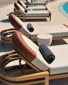 lounge chairs with towels on them next to a swimming pool