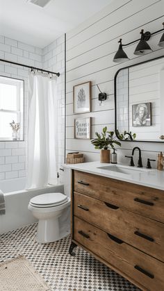 a white bathroom with black and white checkered flooring, wood vanity, and large mirror