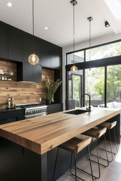 a modern kitchen with black cabinets and wooden counter tops, along with bar stools