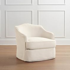 a white chair sitting on top of a hard wood floor in front of a wall