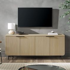 a living room with a large flat screen tv mounted on the wall above a coffee table