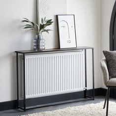 a white radiator sitting on top of a wooden table next to a chair