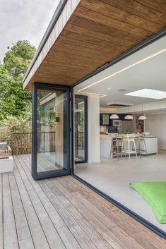 an outdoor living area with wooden flooring and sliding glass doors