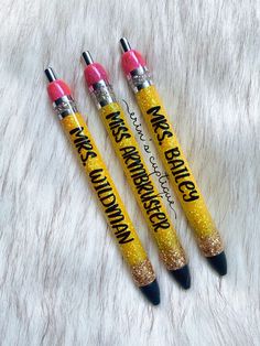 three yellow and pink pens sitting on top of a white fur covered floor next to each other