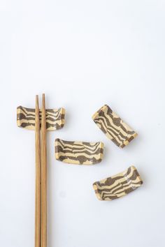 chopsticks and zebra print pieces on a white surface