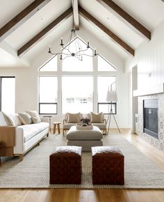 a living room with couches, chairs and a fire place in the middle of it