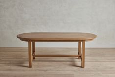 a wooden table sitting on top of a hard wood floor next to a white wall