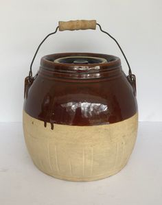 a brown and white ceramic pot with handle