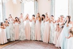 a group of women standing next to each other in front of a window with their hands together