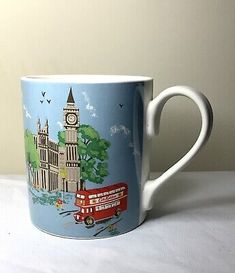 a blue and white coffee cup with a red bus in front of the clock tower