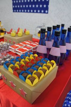 a table filled with desserts and drinks on top of red white and blue plates