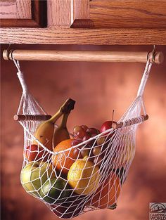 a fruit basket hanging from a wooden shelf