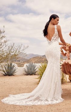 a woman in a wedding dress standing next to a horse