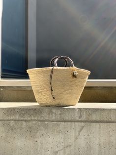 The Brigitte bag is our very modern version of the traditional Panier basket. The basket, handmade by artisans in Spain in palm leaf straw, is covered in a metallic gold mesh, and the short handles coiled in brown leather. It is lined in dark brown cotton fabric, with leather drawstring with metal star charms. The bag is finished with a Cuckoo B keychain featuring a buffalo horn star made in Vietnam, a handmade in Argentina ceramic white star and the Cuckoo B bronze tag. It is inspired on Summer Brown Cotton Fabric, Metal Star, Metal Stars, White Star, Palm Leaf, Star Charms, Metallic Gold, Straw Bag, Horn