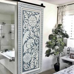 a bathroom with a white bath tub next to a large window and a potted plant in the corner