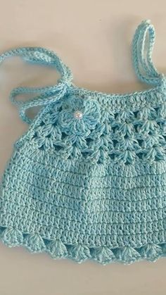 a blue crocheted purse with a bow on the shoulder