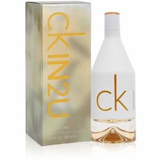 a bottle of perfume sitting next to a box on a white surface with gold lettering