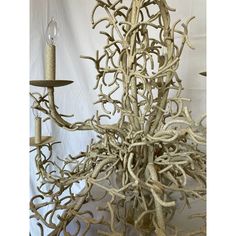 a chandelier made out of antler branches with a candle on the side