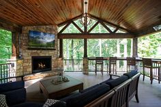 a living room filled with furniture and a fire place in the middle of a forest