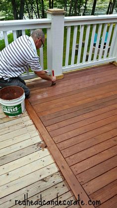 an older man is painting the deck with brown paint and a bucket of red dye