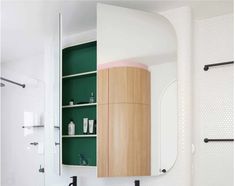 a bathroom with green and white accessories on the wall, including a cabinet in the middle