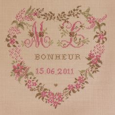 a cross - stitch heart with the words me and you in pink flowers on it