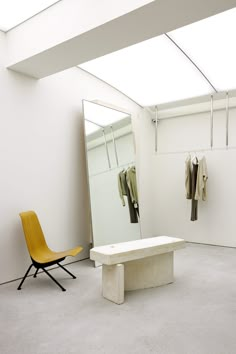 a room with a chair, coat rack and mirror