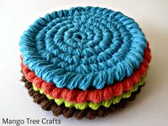 four crocheted coasters stacked on top of each other in different colors and sizes