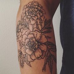 a woman's arm with black and white flowers on the left side of her arm