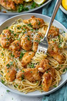 two plates of pasta with shrimp and parmesan cheese on the side, one has a fork in it