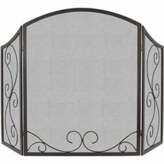 an iron fireplace screen with scroll designs