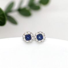 These beautiful stud earrings feature a pair of 0.30 carat wight Blue Sapphire gemstones with a halo of natural earth mined diamonds set in solid 14K gold. These Blue Sapphire studs make a lovely September birthstone gift for your loved ones! These earrings are made with solid 14k Gold and natural earth mined SI / G-H Diamonds. As listed, these earrings are ready to ship. If you're interested in purchasing this setting with a different center stone please message us! Blue Diamond Earrings With Halo Design For Anniversary, Diamond Cluster Earrings With Gemstones For Anniversary, Fine Jewelry Sapphire Earrings With Halo Design, Sapphire Earrings With Halo Design Fine Jewelry, Sapphire Halo Earrings Fine Jewelry, 14k White Gold Cluster Halo Jewelry, Sapphire Diamond Earrings For Wedding, Sterling Silver Cluster Earrings With Round Cut Halo, White Gold Round Gemstone Cluster Earrings