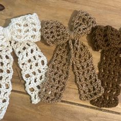 three crocheted scarves tied together on a wooden floor