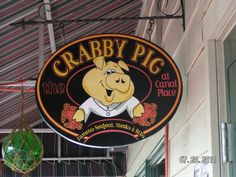 the sign for crabby pig at canal place hangs from the side of the building