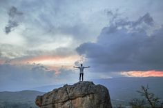 a person standing on top of a large rock