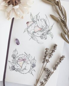 some flowers are sitting on top of a piece of paper next to a pencil and ink drawing