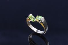 You will be thinking Spring with these fancy emerald cut apple green peridots in our 14K yellow gold ring! With clean lines and a mod retro look, this ring is sure to become a favorite! We will size this ring up to a size 7.5 free of charge. If you would like this ring larger please contact us before ordering! Free shipping in the USA! Green Peridot Birthstone Ring For Formal Occasions, Green Peridot Birthstone Ring For Formal Events, Emerald Cut Peridot Ring For Anniversary, Emerald Cut Peridot Ring In Green, Green Emerald Cut Peridot Ring, Emerald Cut Peridot Green Ring, Modern Peridot Rings For Anniversary, Modern Green Rings With Prong Setting, Formal Green Ring With Tension Setting