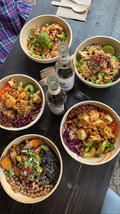 several bowls of food are arranged on a table