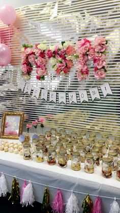 a table topped with lots of desserts next to pink and white flowers on top of it